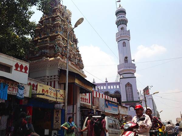  This minaret and spire in a Bangalore bazaar has a multitude of shops at their base, visited by all. 
