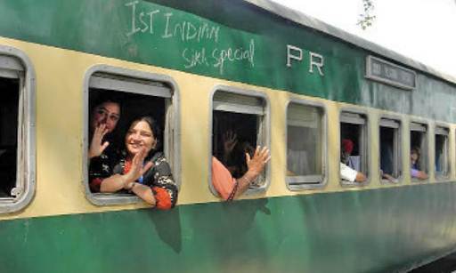 Description: Women wave as they set off for their journey back home to India on a special pilgrim train. — Photos by the writer