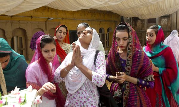 Description: Female pilgrims raise their hands as a gesture of praying. -Reuters