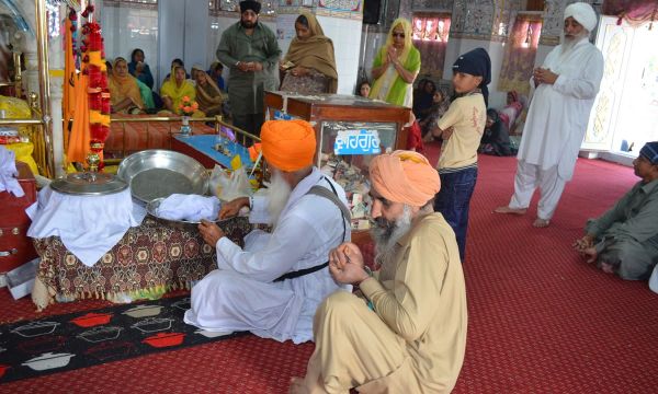 Description: 'Parshad' is distributed amongst the pilgrims.