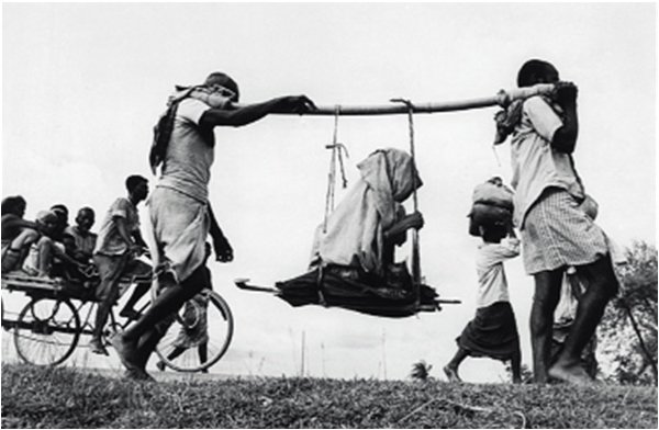 Description: Two men carrying a woman – 1947