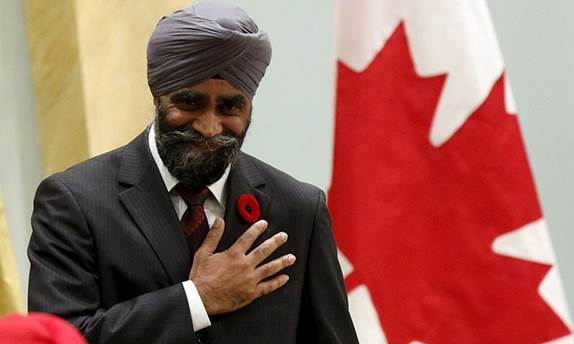 Description: Canada's new National Defence Minister Harjit Sajjan gestures after being sworn-in during the ceremony. — Reuters/File