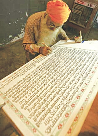 Description: A scribe copies the Guru Granth Sahib by hand in the northern Indian city of Amritsar | Reuters