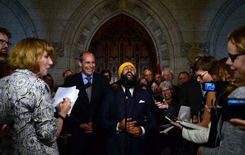 Description: NDP Leader Jagmeet Singh revels in the spotlight with his newly announced parliamentary leader, Guy Caron, left, at the House of Commons last week.