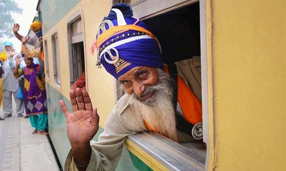 Description: Sikh yatrees wave upon their arrival at Wagah Railway Station. — Online