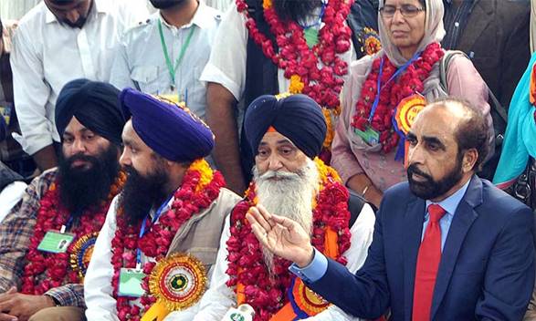 Description: Siddique ul Farooq receives Sikh pilgrims at Wagah Railway Station. — APP
