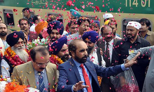 Description: Sikh devotees are showered with rose petals upon their arrival at Wagah border. — APP