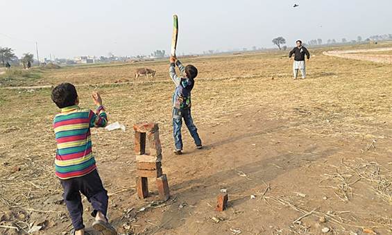 Description: Kids playing cricket next to Puran’s well.