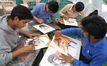 Description: School boys draw portraits at a competition in Amritsar.