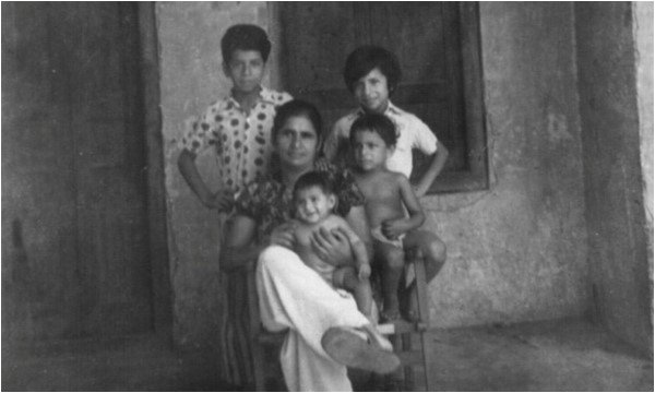 Description: The author's mother and siblings in front of the room that his family lived in, during the 1960s