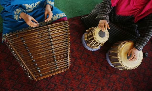 Description: Kashmiri Muslim girls play Sufi music on various instruments, such as the Santoor and tabla (pictured above) under the tutelage of their music teacher on the outskirts of Srinagar.