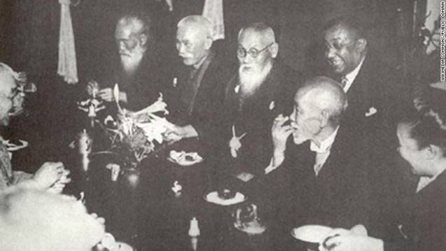 Description: A dinner party held in honor of  Bose in 1915 by his close Japanese friends, including Mitsuru Tōyama (centre, behind the table), and Tsuyoshi Inukai (to the right of Tōyama). Bose is pictured behind Tōyama is Bose.