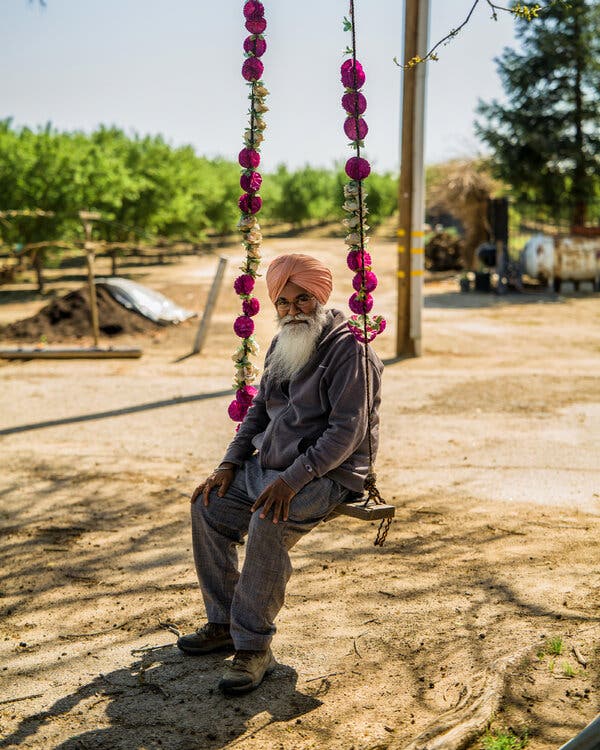 Description: Sarbjit Sran sits on a swing at his family farm in Kerman, Calif. The family grows almonds and grapes on a 100-acre homestead.