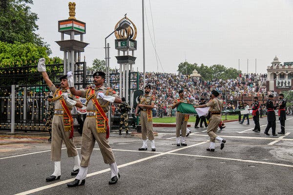 Description: Indian forces during the pomp-filled ceremony, with Pakistani forces in the background.